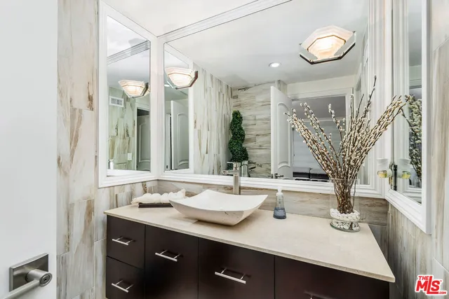 a bathroom with a sink vanity and a mirror