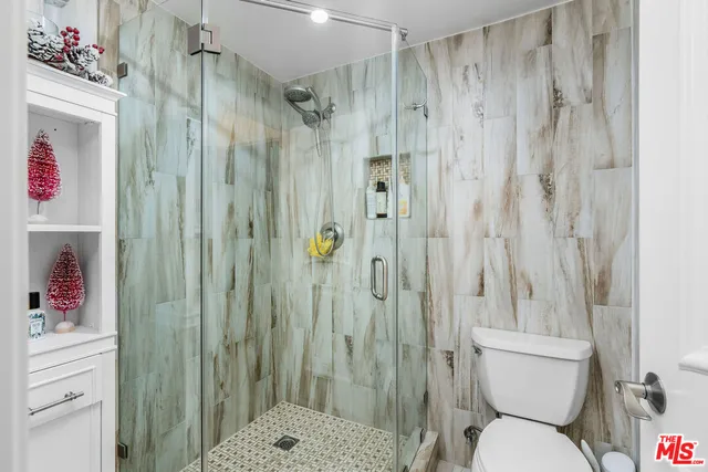 a bathroom with a shower a toilet and a sink