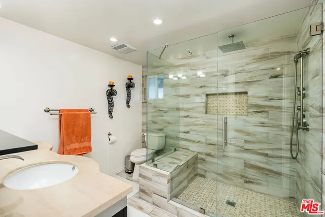 a bathroom with a sink mirror and shower