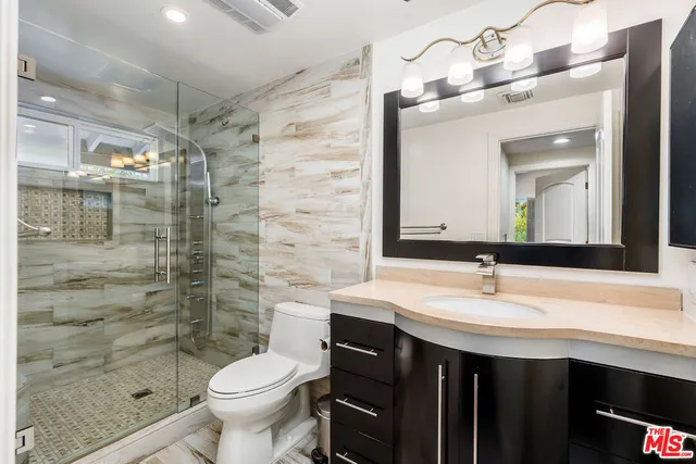 a bathroom with a sink a toilet and shower