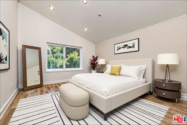 a bedroom with a bed and wooden floor