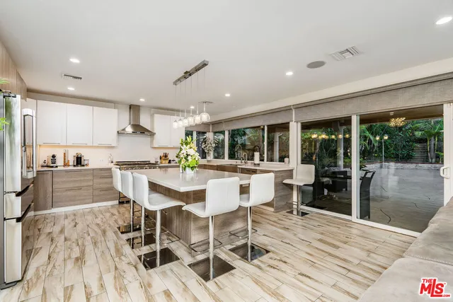 a dining room with stainless steel appliances kitchen island granite countertop a dining table chairs and view living room