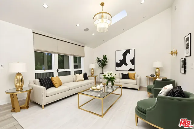 a living room with furniture chandelier and a large mirror