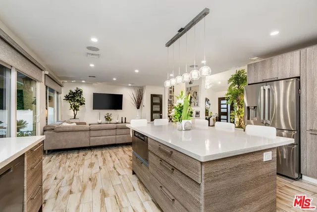 a large white kitchen with a large window and stainless steel appliances