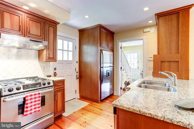 a kitchen with stainless steel appliances granite countertop a stove a sink and a refrigerator