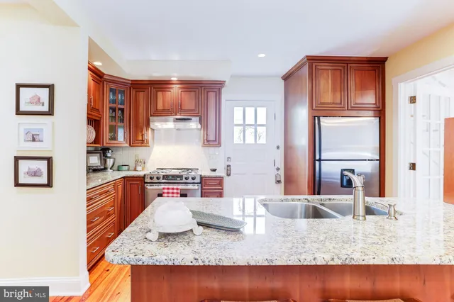 a kitchen with stainless steel appliances granite countertop a stove a sink and a microwave