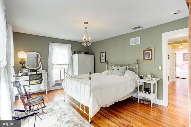 a bed room with a bed a chandelier and dresser