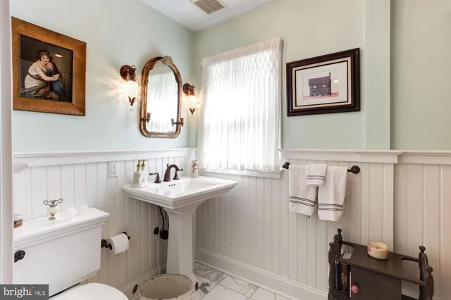 a bathroom with a sink mirror and toilet