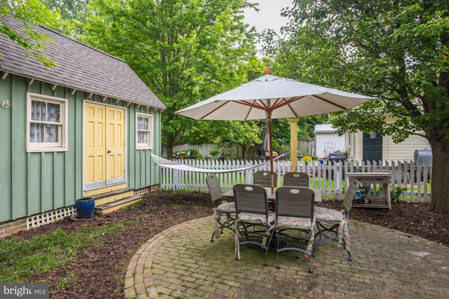 a view of a garden with a table and chairs under an umbrella