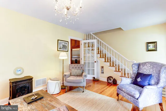 a living room with furniture a fireplace and a chandelier