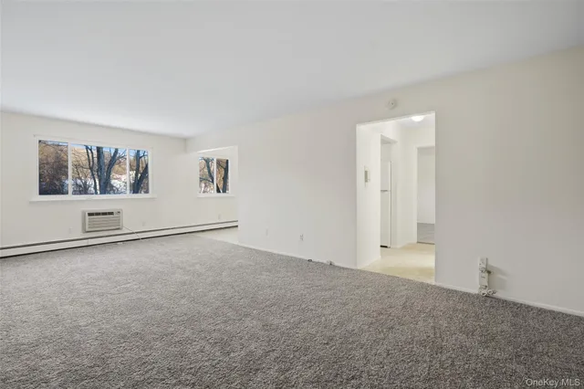 an empty room with windows and cabinet