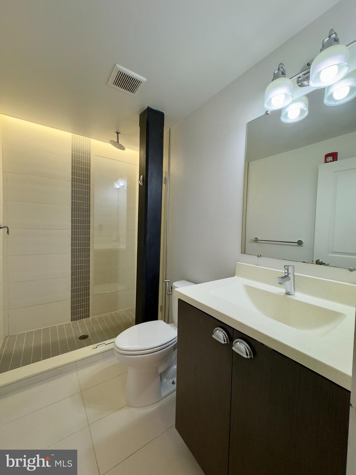 613 Portland Street, Unit 17 Baltimore, MD 21230 - Photo 11 of 12 a bathroom with a sink a toilet a mirror and shower