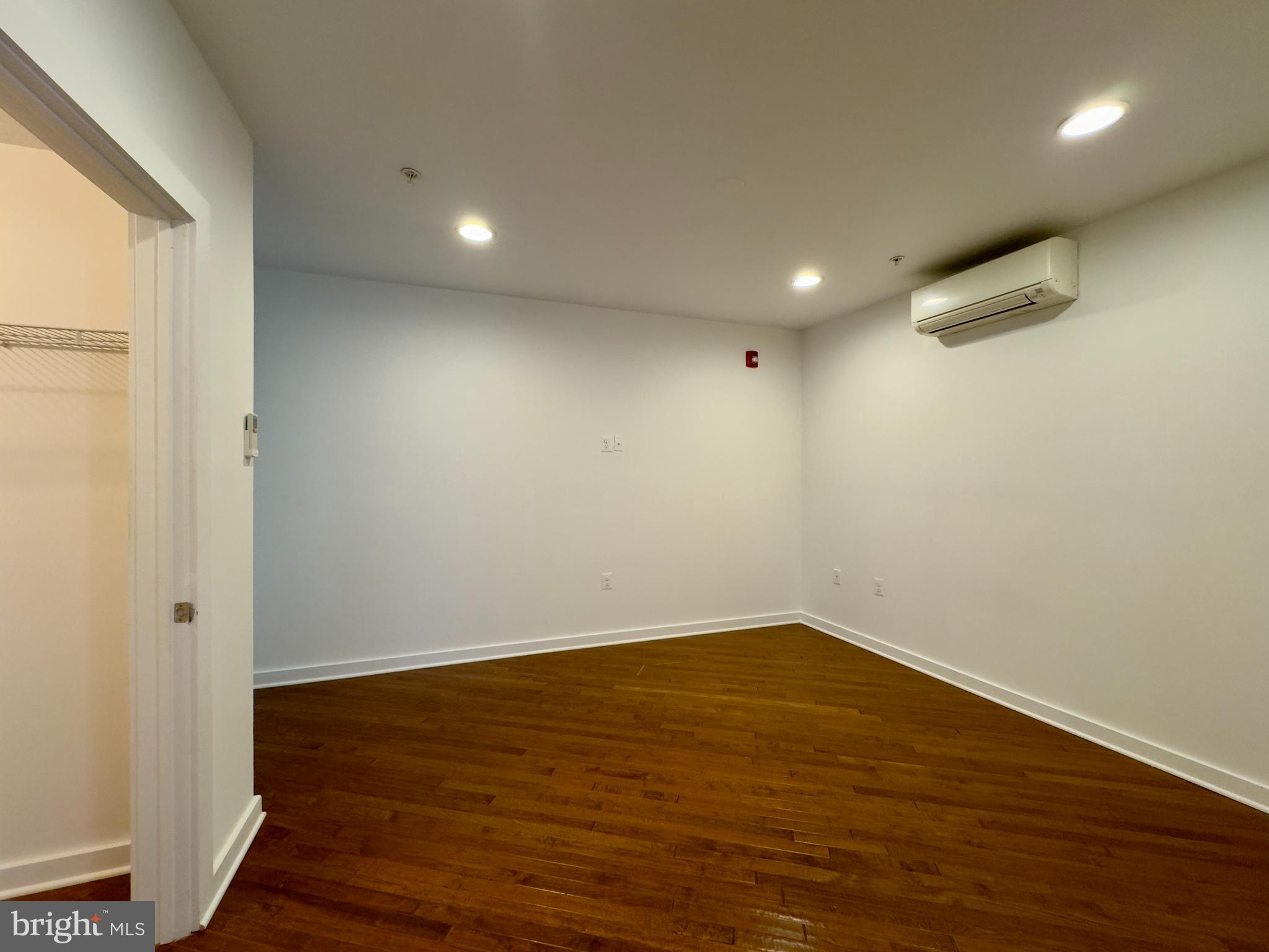 613 Portland Street, Unit 17 Baltimore, MD 21230 - Photo 8 of 12 an empty room with wooden floor and windows