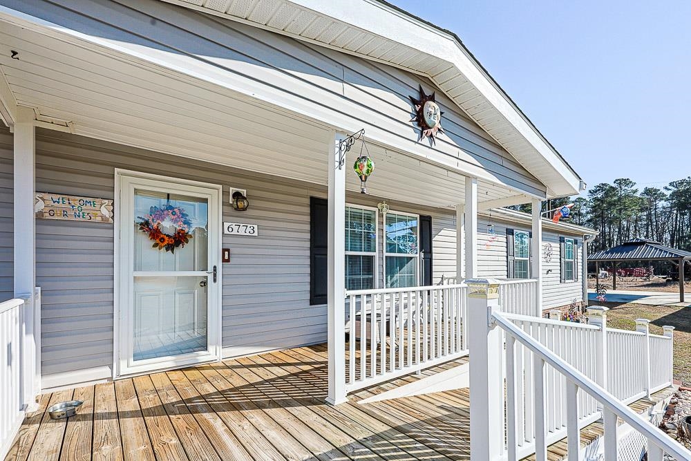 Doorway to property with a porch and a ramp