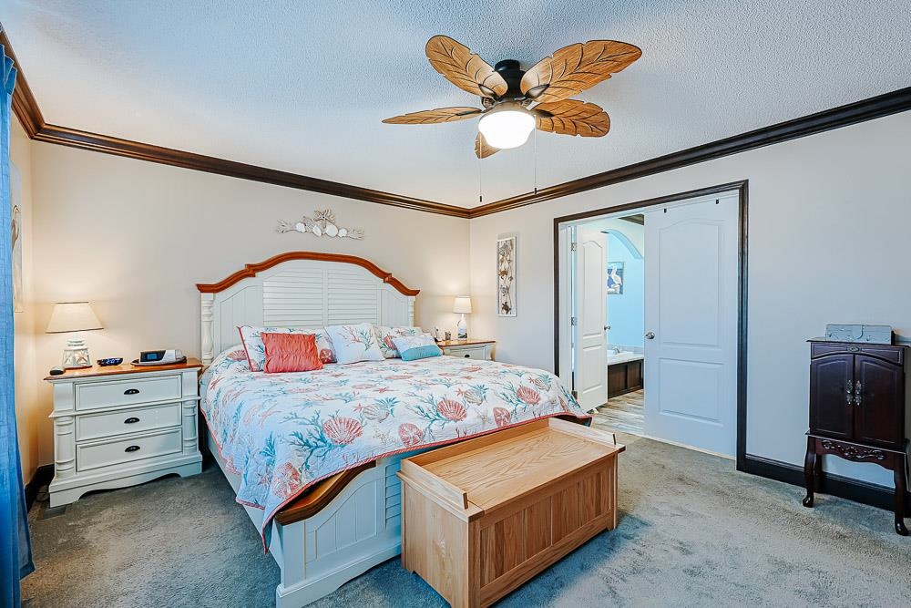 6773 Hampton Road Conway, SC 29527 - Photo 12 of 39 Bedroom featuring crown molding, carpet, a ceiling fan, a textured ceiling, and ensuite bathroom
