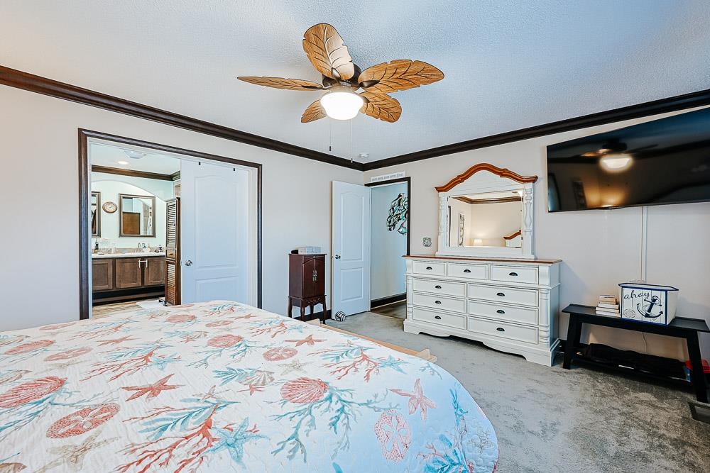 6773 Hampton Road Conway, SC 29527 - Photo 13 of 39 Bedroom featuring crown molding, ceiling fan, light colored carpet, and ensuite bath