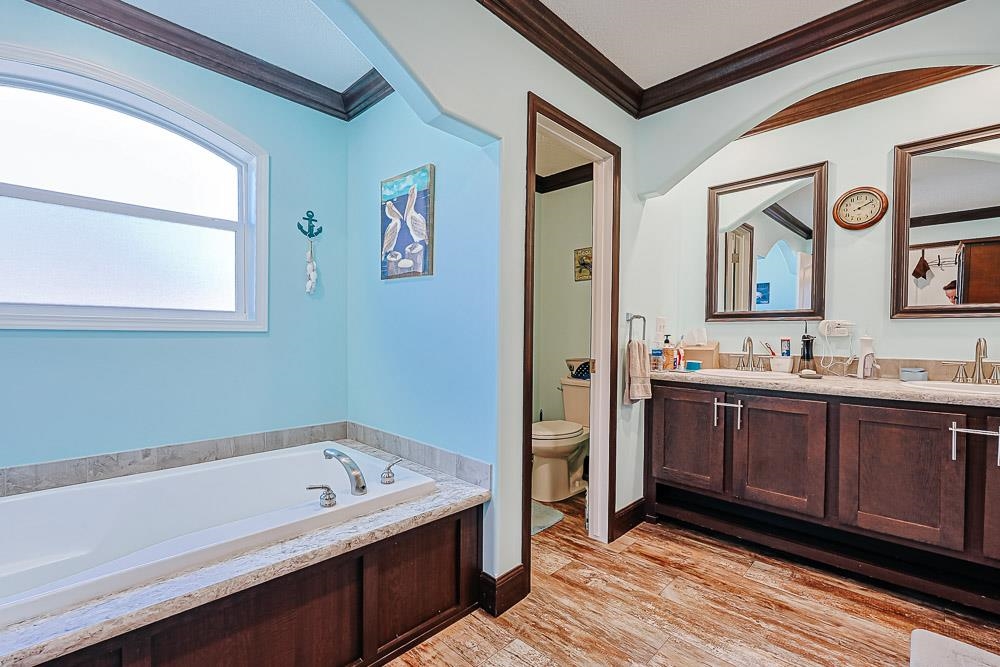 6773 Hampton Road Conway, SC 29527 - Photo 16 of 39 Bathroom with double vanity, crown molding, light wood-style flooring, and a garden tub