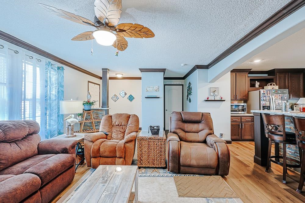 6773 Hampton Road Conway, SC 29527 - Photo 5 of 39 Living area featuring LVP flooring, ornamental molding, a ceiling fan, and a textured ceiling