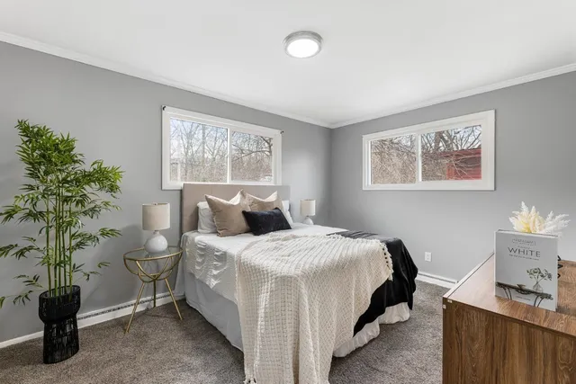 a bedroom with a bed and a potted plant