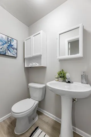 a bathroom with a toilet a sink and mirror