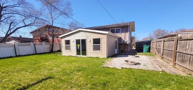 a backyard of a house with table and chairs