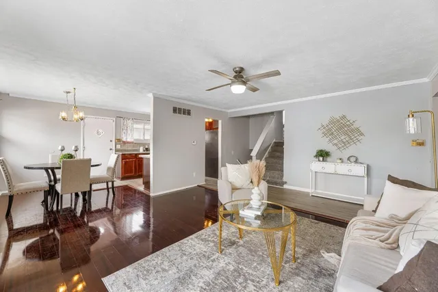 a living room with furniture dining table a lamp and a dining table with wooden floor