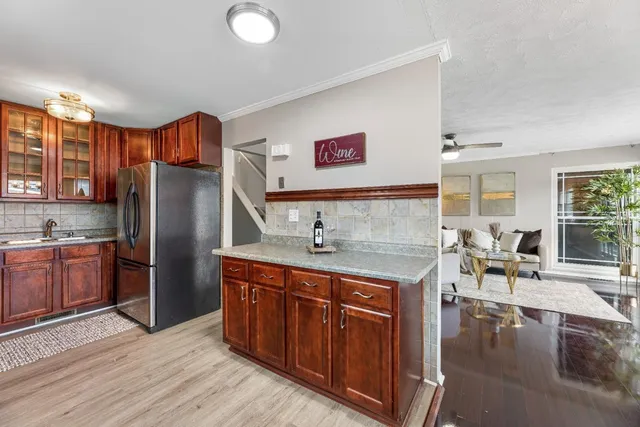 a kitchen with stainless steel appliances granite countertop a sink a stove and refrigerator