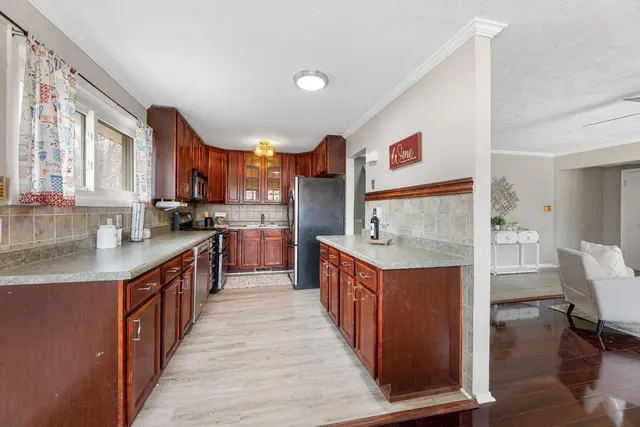 a kitchen with stainless steel appliances granite countertop a stove top oven a sink dishwasher and cabinets with wooden floor