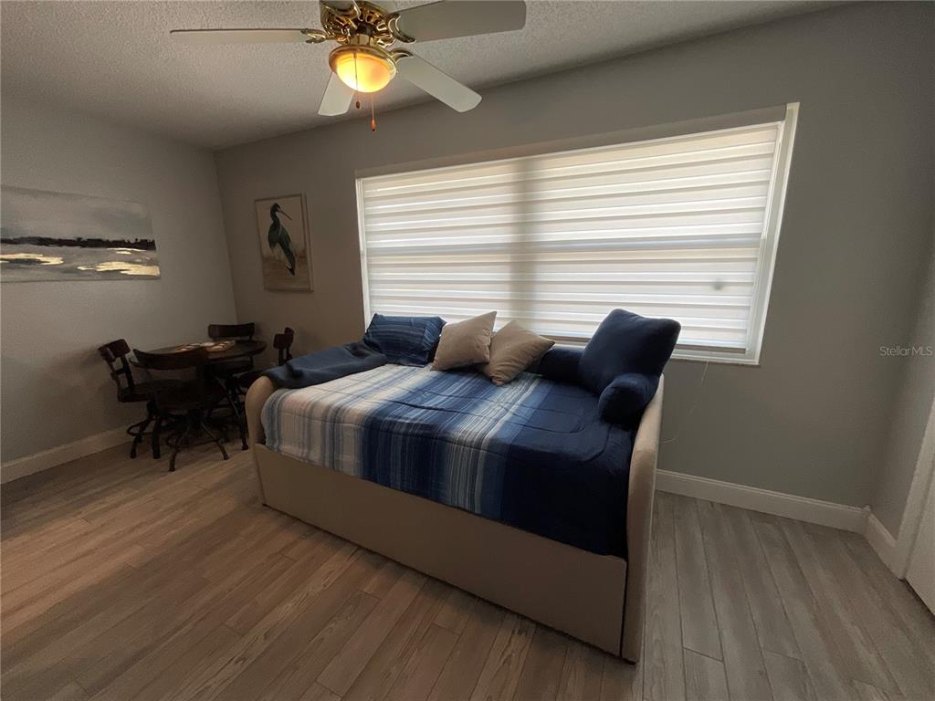 10036 63rd Avenue North, Unit 16 St. Petersburg, FL 33708 - Photo 13 of 30 a bedroom with a bed and a chandelier