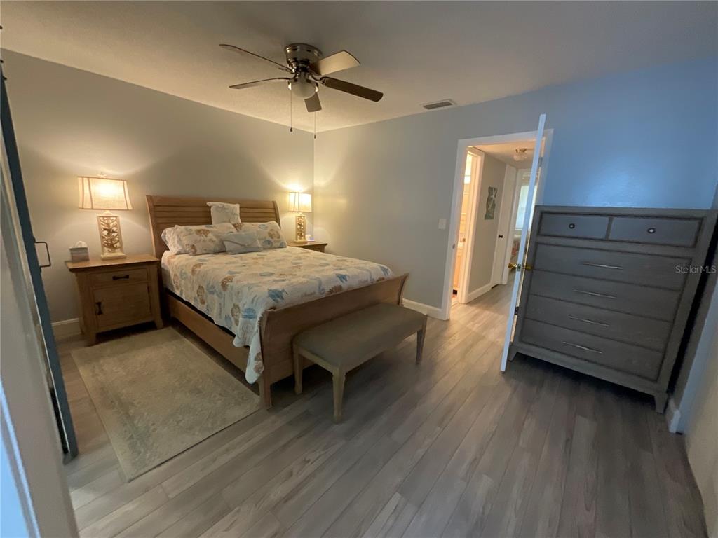 10036 63rd Avenue North, Unit 16 St. Petersburg, FL 33708 - Photo 15 of 30 a spacious bedroom with a bed and wooden floor