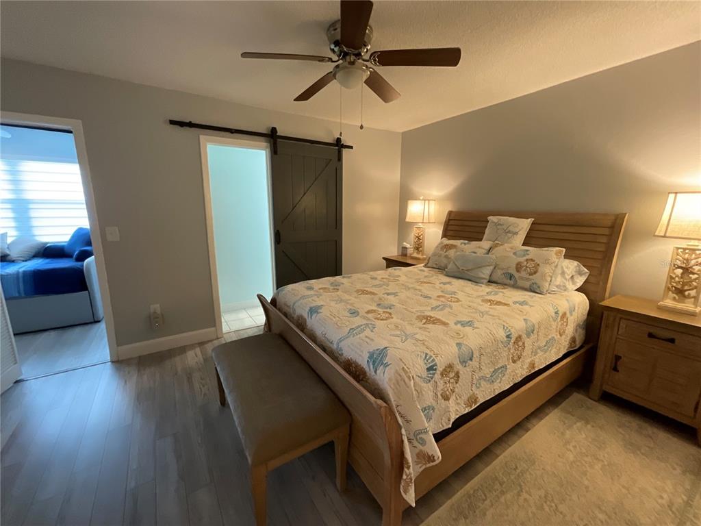 10036 63rd Avenue North, Unit 16 St. Petersburg, FL 33708 - Photo 18 of 30 a bedroom with a bed and a chandelier