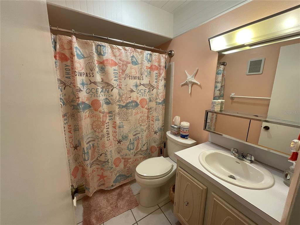 10036 63rd Avenue North, Unit 16 St. Petersburg, FL 33708 - Photo 21 of 30 a bathroom with a granite countertop sink toilet and shower