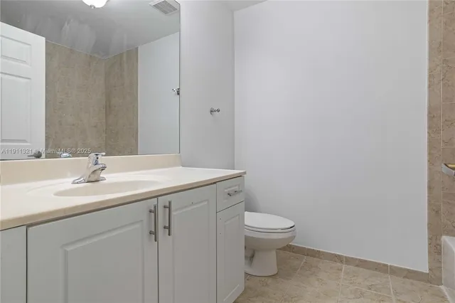 a bathroom with a granite countertop sink a toilet and a mirror