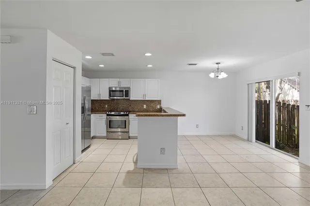 a view of kitchen with refrigerator and cabinets
