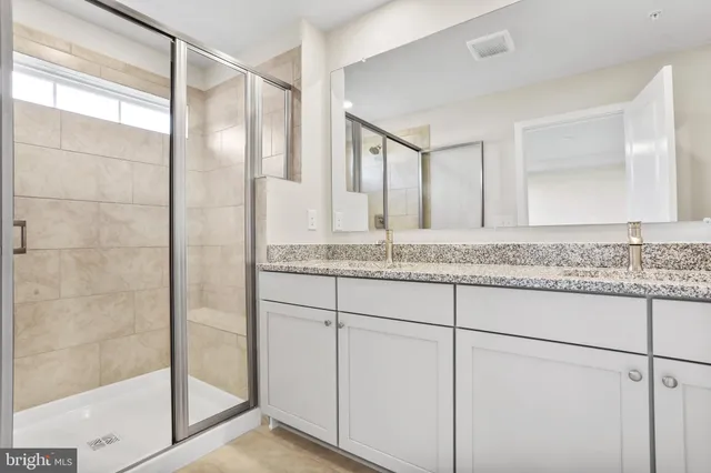 a bathroom with a granite countertop sink and mirror