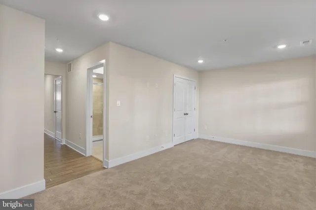 an empty room with staircase and bathroom view