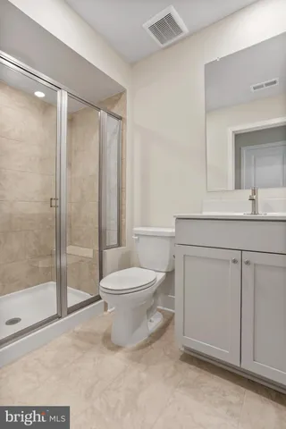 a bathroom with a toilet a sink and glass door