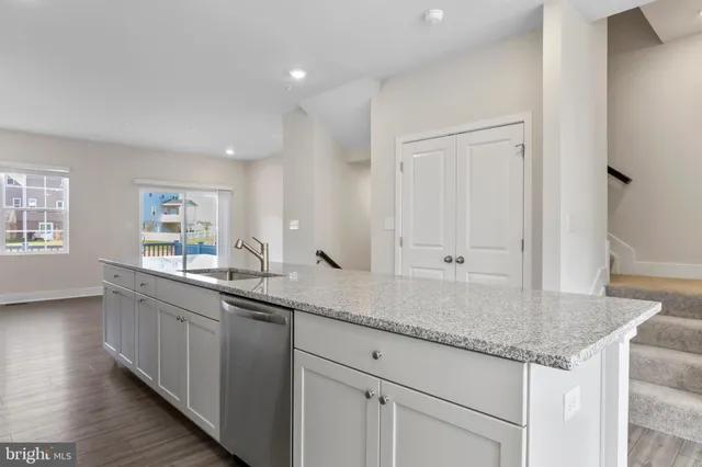a kitchen with granite countertop kitchen island a sink appliances and cabinets