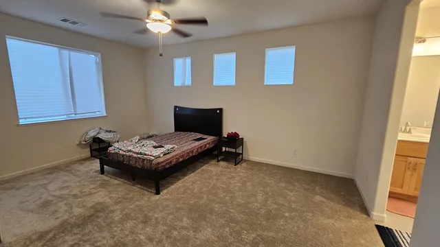 a bedroom with a bed and a lamp on the dresser