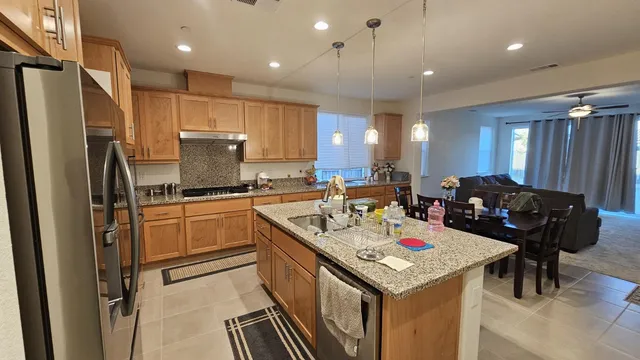 a kitchen with a refrigerator a sink and chairs