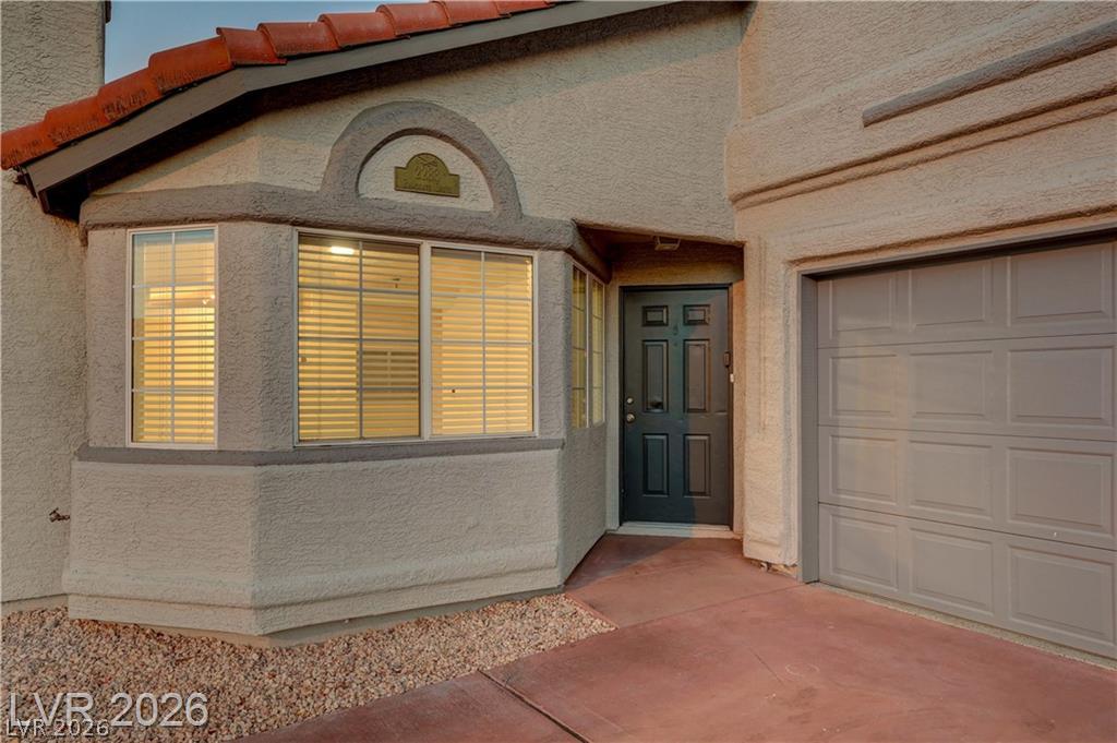 An inviting stucco exterior showcases a prominent bay window alongside a secure attached garage.