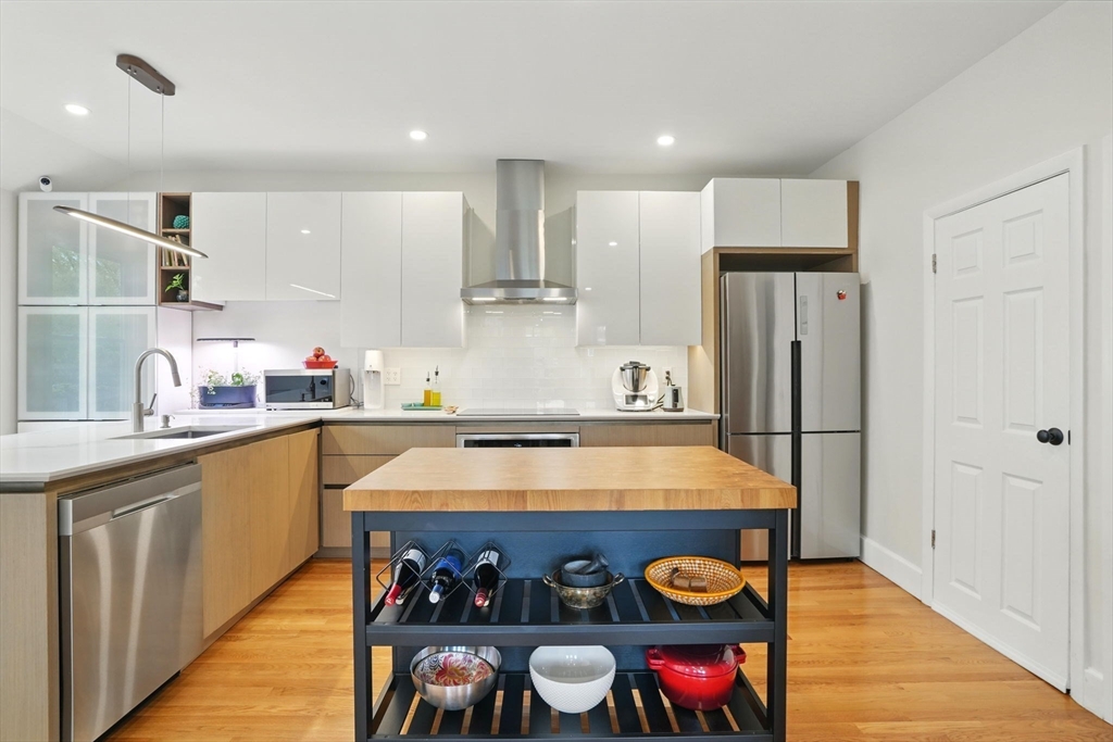 25 Bowdoin Street Somerville, MA 02143 - Photo 11 of 28 a kitchen with stainless steel appliances granite countertop a refrigerator and a stove top oven