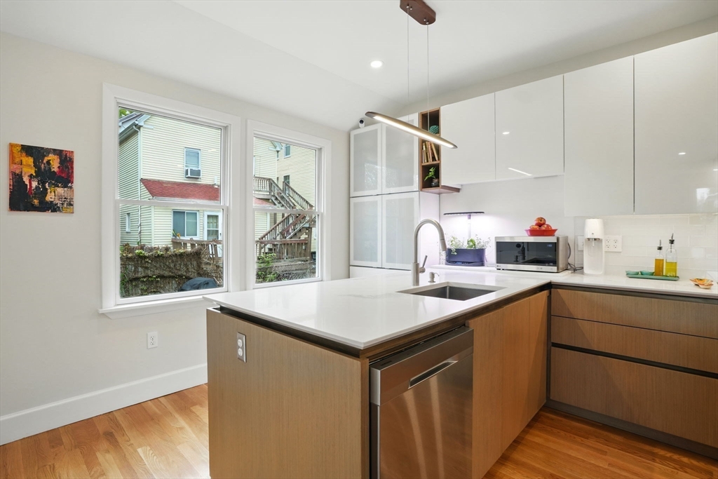 25 Bowdoin Street Somerville, MA 02143 - Photo 9 of 28 a kitchen with stainless steel appliances granite countertop a sink stove and refrigerator