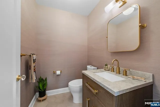 a bathroom with a granite countertop sink a toilet and a mirror