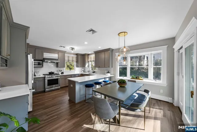 a open kitchen with a table chairs stove and wooden floor