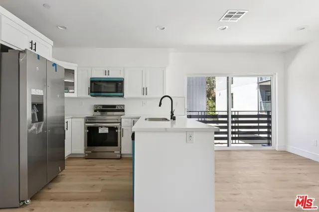 a kitchen with stainless steel appliances a refrigerator stove and oven