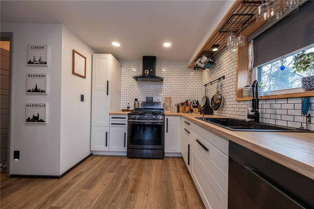 7608 Cheyenne Street Pittsburgh, PA 15218 - Photo 15 of 33 a kitchen with stainless steel appliances granite countertop a refrigerator a sink dishwasher a stove and white countertops with wooden floor