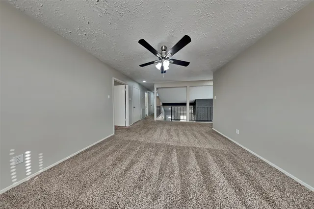 a view of empty room with a ceiling fan and window