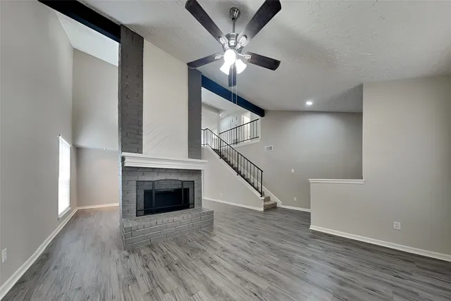 wooden floor fireplace and windows in an empty room