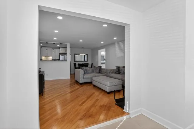 a living room with furniture and a view of kitchen